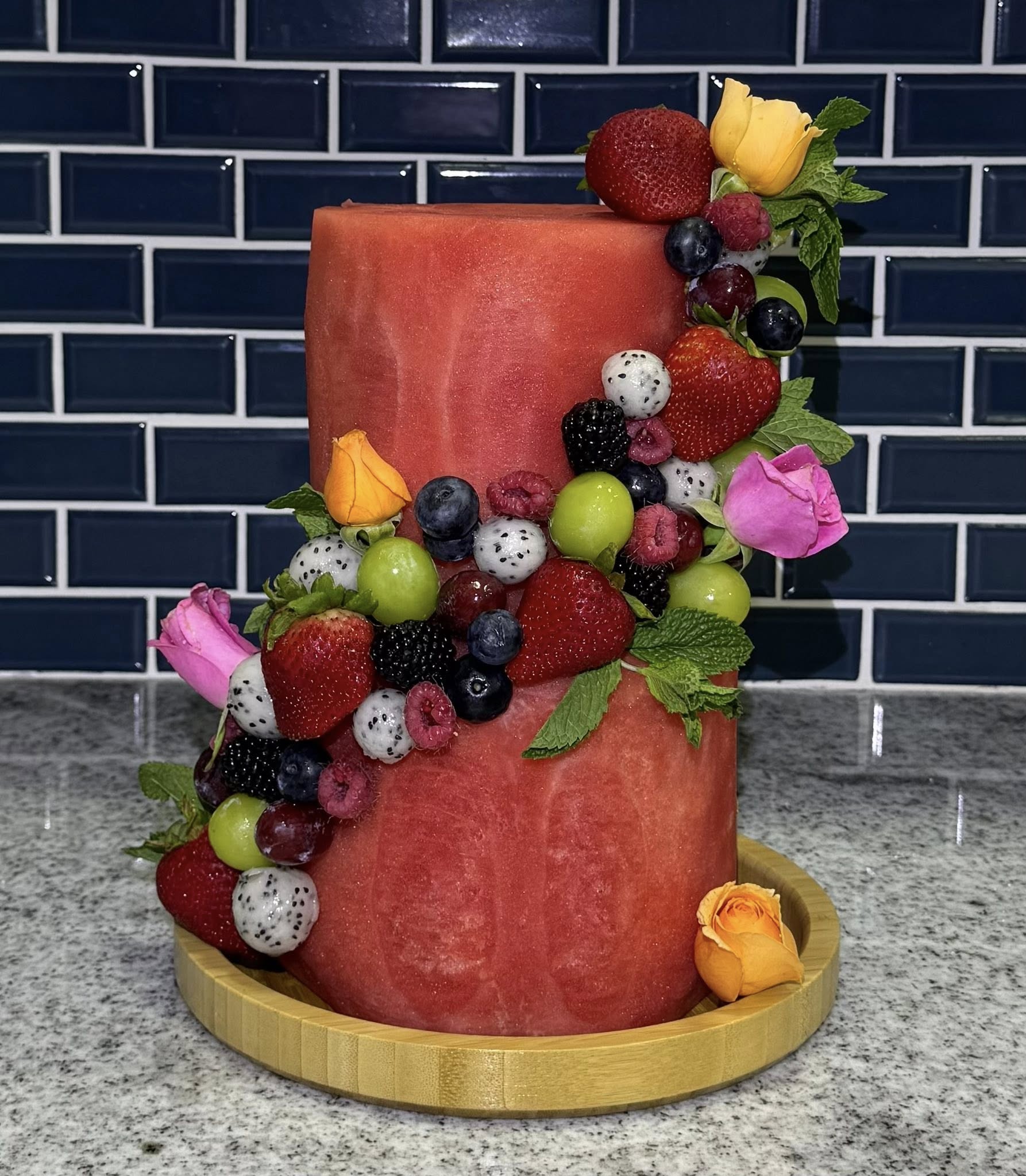 Carved watermelon fruit cake with fresh berries and roses