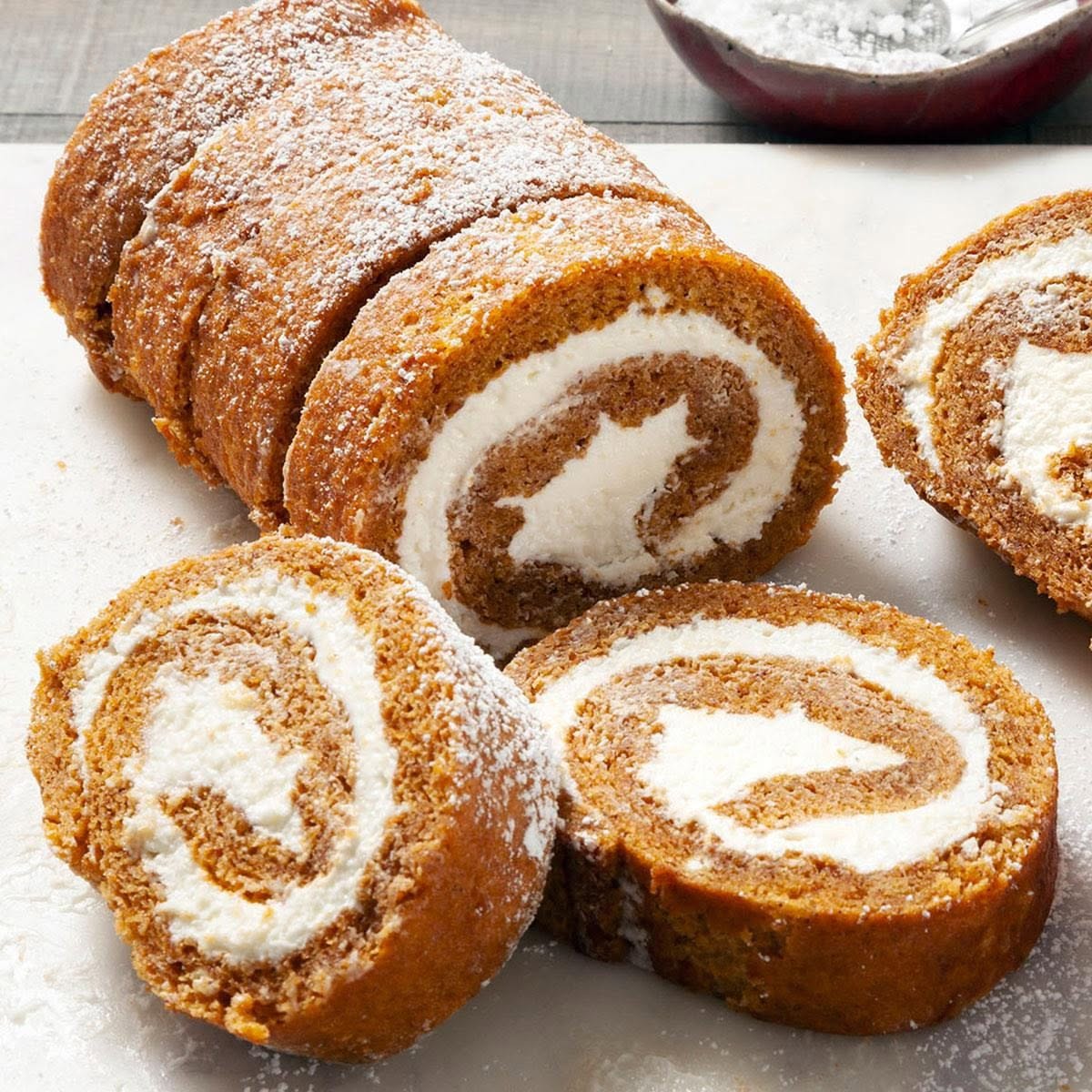 Pumpkin cream cheese roll cake dusted with powdered sugar